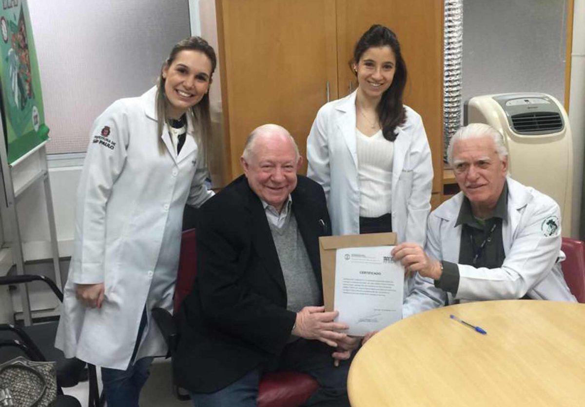 O Prof. Dr. Fagundes faz a entrega do Certificado de Palestrante ao Prof. Dr. Sidnei Martini, ao lado da Dra. Nathalia Targa e a Auxiliar de Enfermagem Natali Castro