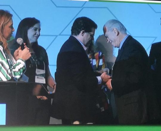 O Dr. Beni Grimblat entrega o troféu de Colaborador Científico da Dermatologia Paulista