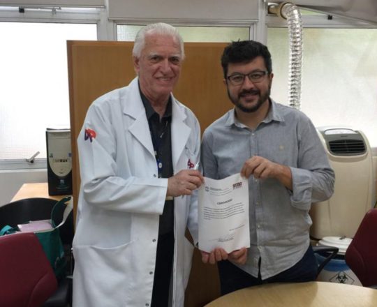 O Prof. Dr. Fagundes faz a entrega do Certificado de Palestrante ao Prof. Carlos Okada