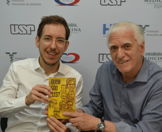 O Prof. Dr. Luiz Jorge Fagundes, faz a entrega de seu Livro “Quem São Eles?” sobre a Hanseníase ao Dr. Marcos Moura.